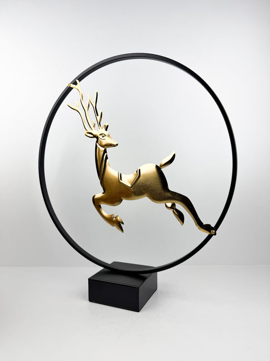 Sculpture décorative moderne représentant un cerf doré bondissant, encadré dans un cercle métallique noir épuré.