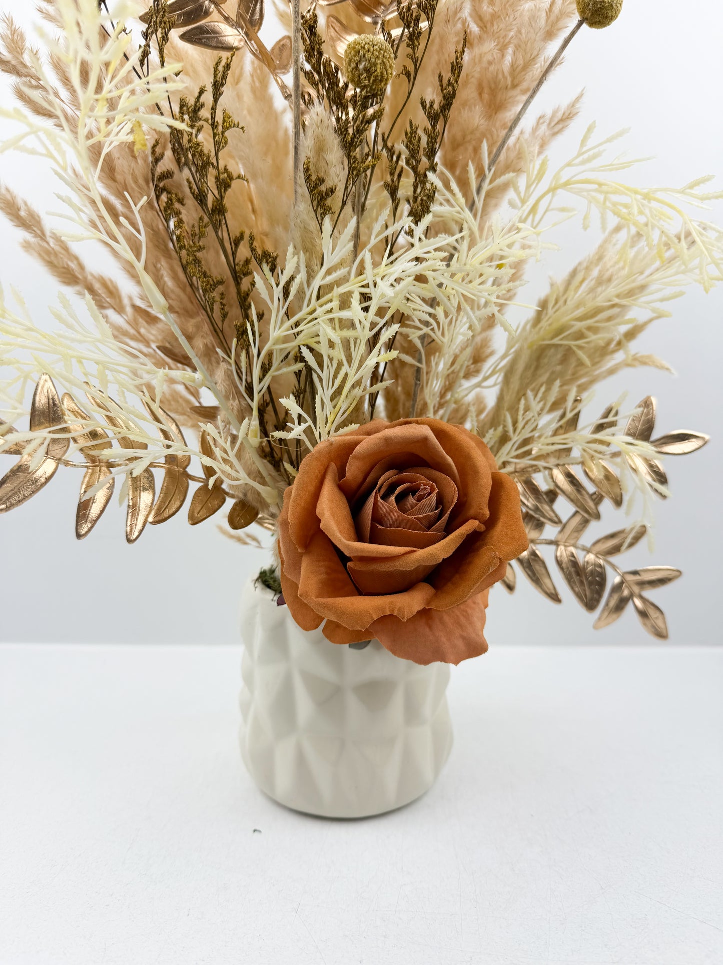 Fleurs séchées beige par une délicate fleur marron dans un vase en céramique beige
