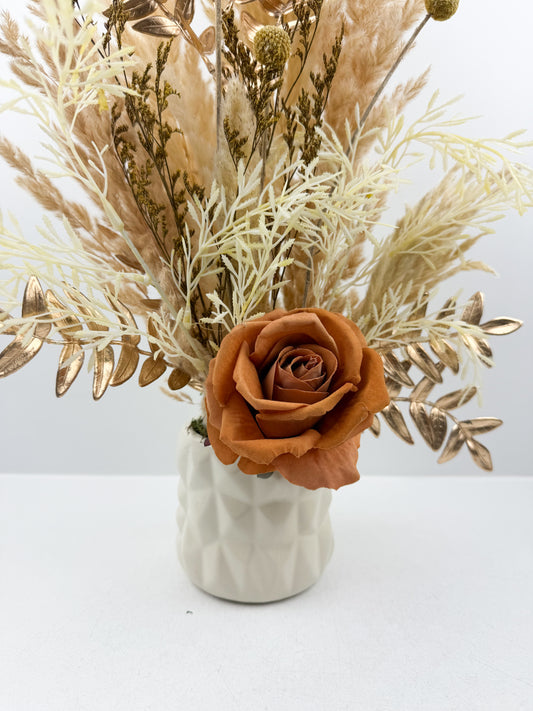 Fleurs séchées beige par une délicate fleur marron dans un vase en céramique beige