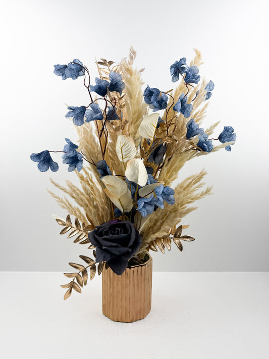 Fleurs séchées dans un vase en céramique doré au design élégant et luxueux.