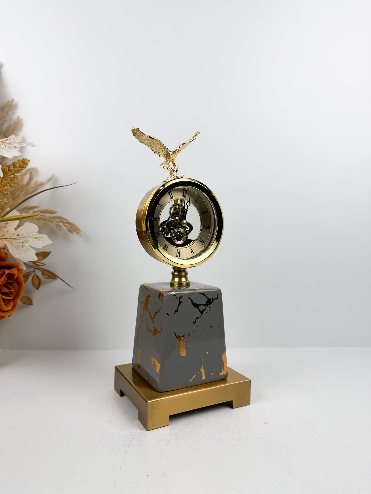 Horloge ronde avec cadran classique surmontée d'une sculpture d'aigle
