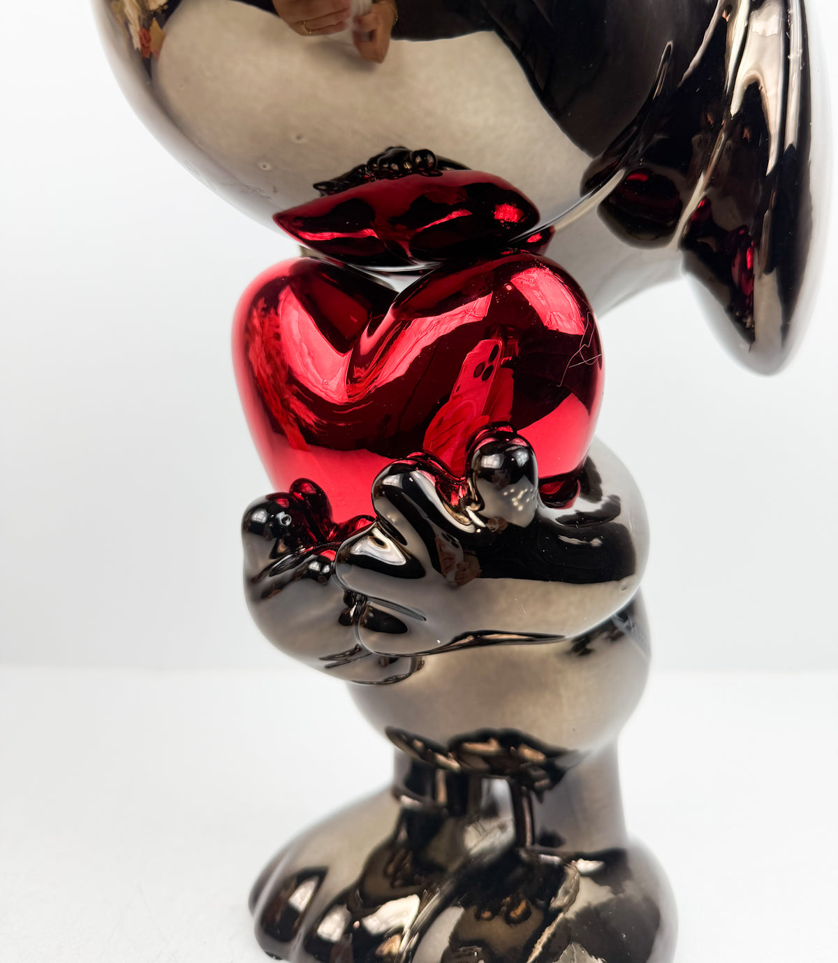 Figurine décorative représentant le célèbre personnage de Snoopy tenant un cœur.