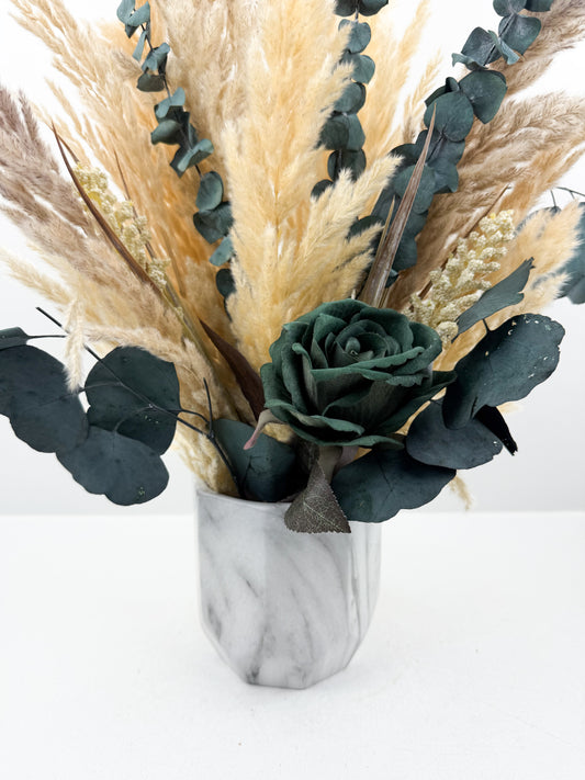 Fleurs séchées rehaussée des fleurs vertes dans un vase en céramique en forme de marbre