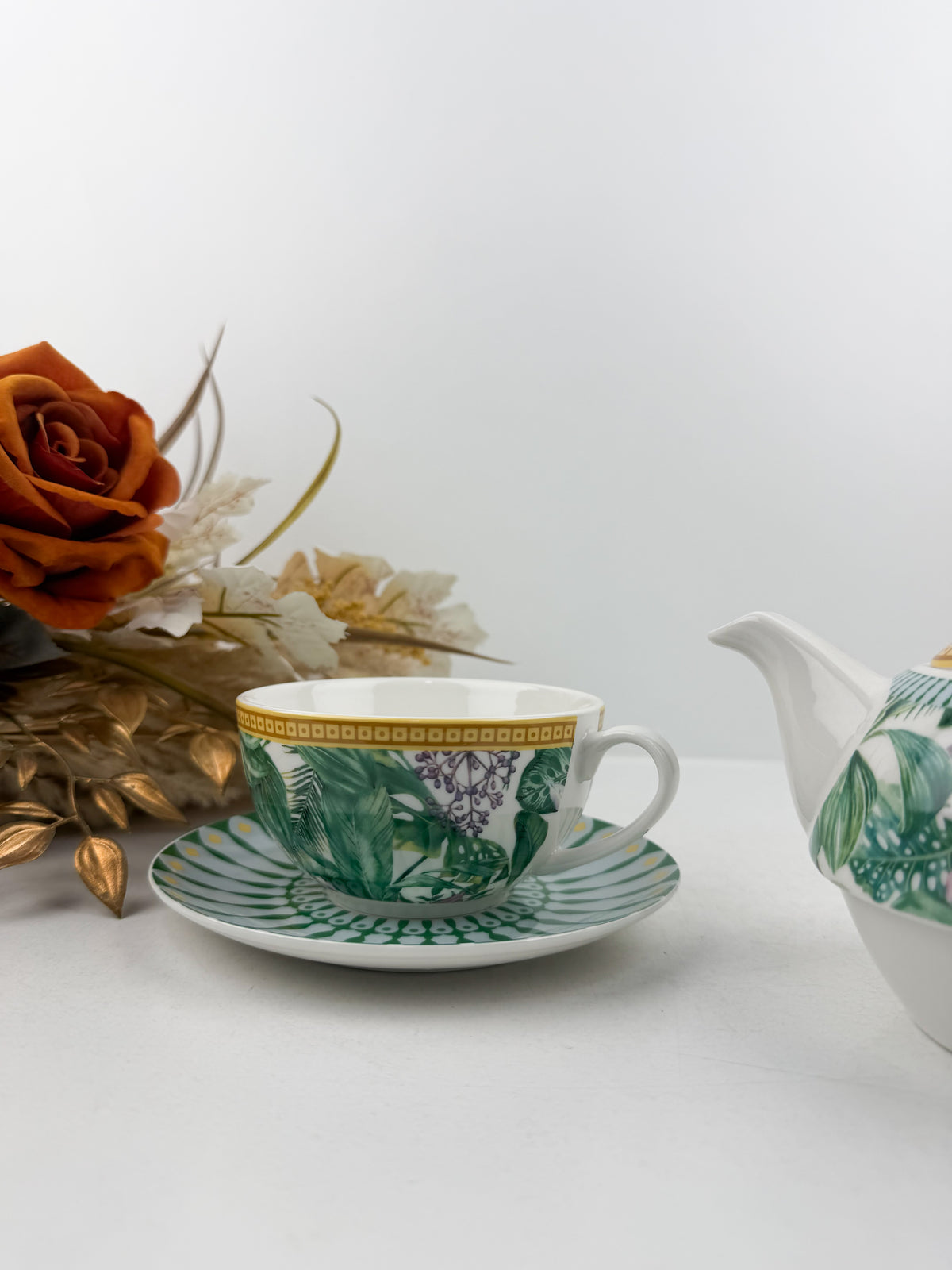 Théière élégante d'une tasse accompagnée de sous-tasse raffinée de motif jungle