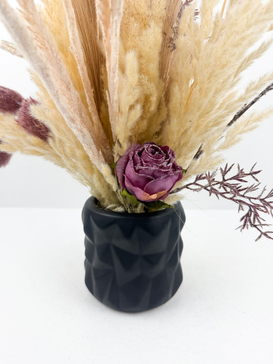 Fleurs séchées aux teintes chaudes et naturelles, présenté dans un élégant vase noir