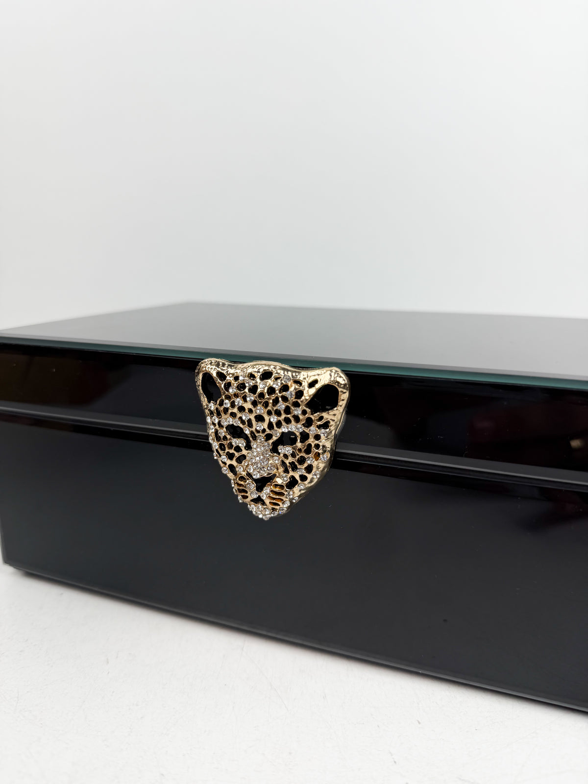 Boîte à bijoux aux finition brillante effet miroir teinté noir.