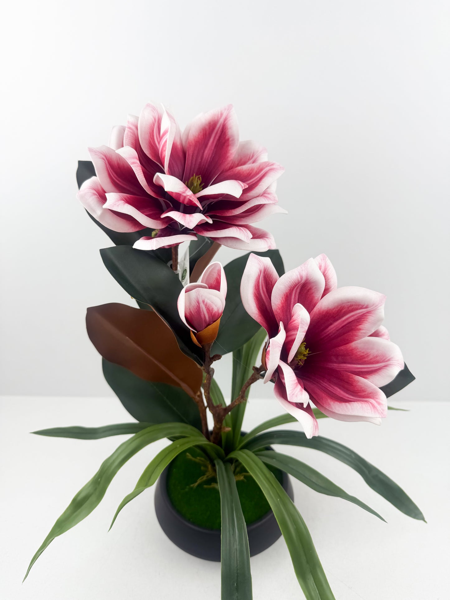 Fleurs artificielles haut de gamme associées à un élégant pot en céramique noir