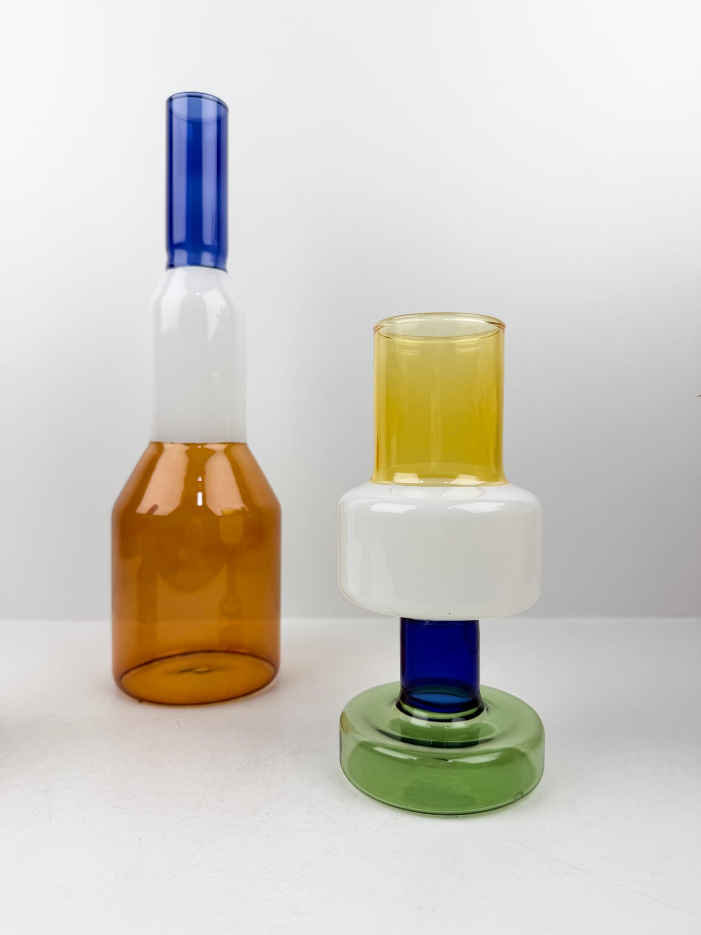Trio de vases géométriques aux formes épurées et aux couleurs variées.