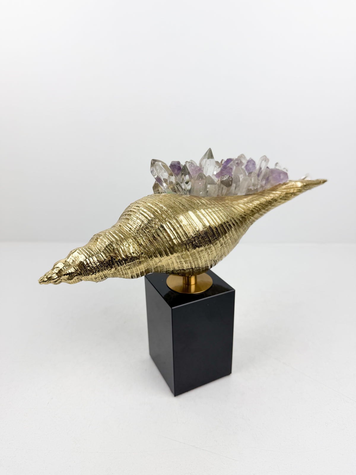 Sculpture de luxe de forme coquillage alliant l'élégance intemporelle du laiton doré aux reflets captivants des cristaux naturels