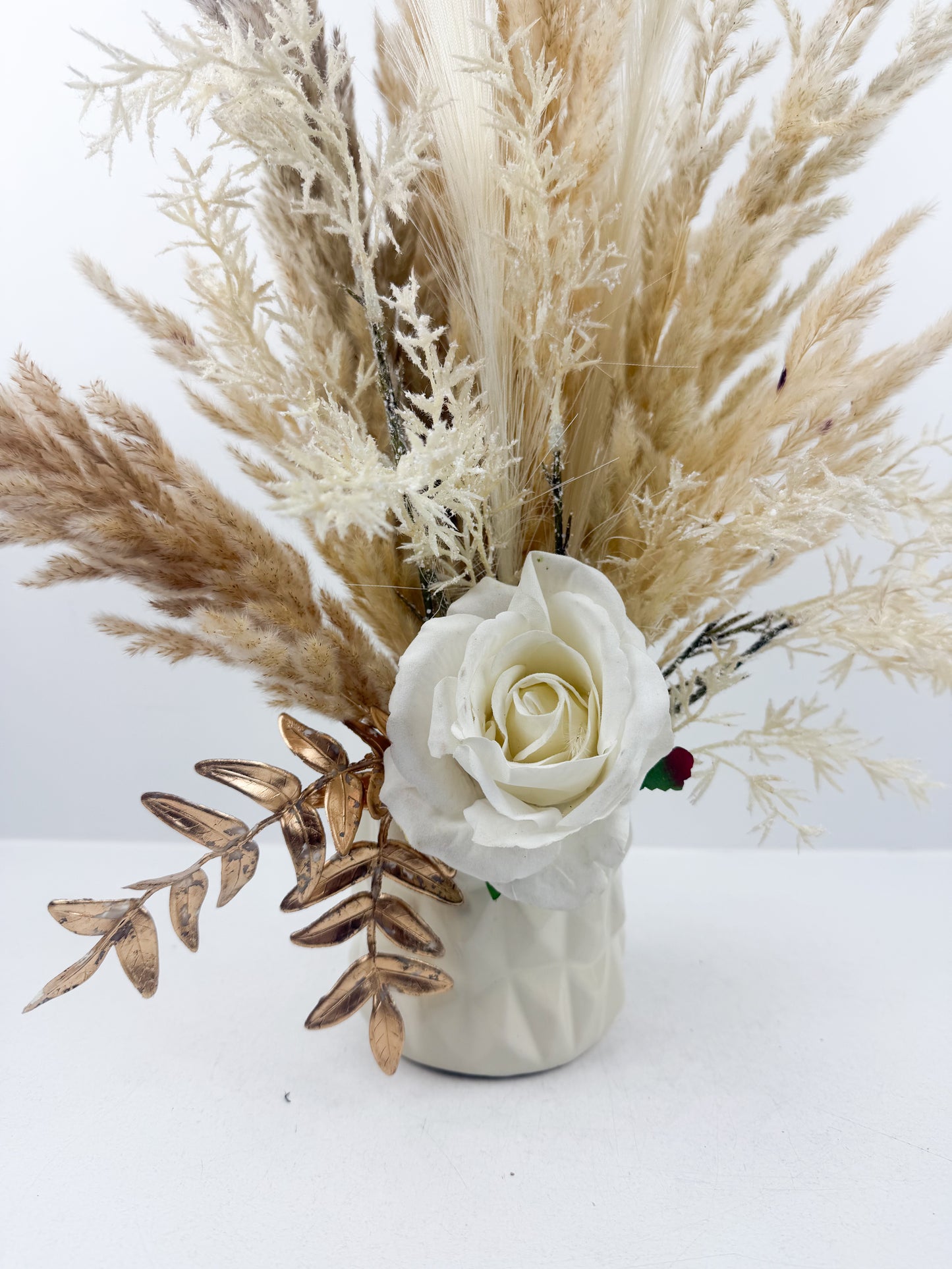 Fleurs séchées aux teintes beige naturels, sublimé par une fleur blanche délicate qui apporte une touche d'élégance intemporelle. 