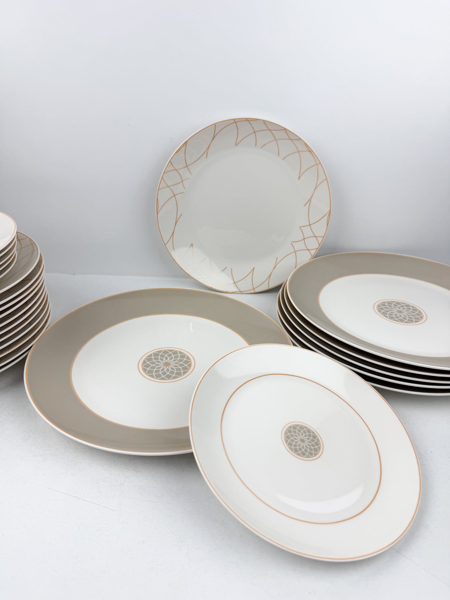 Service de table composé de 36 assiettes en porcelaine de luxe aux motifs élégants beige.