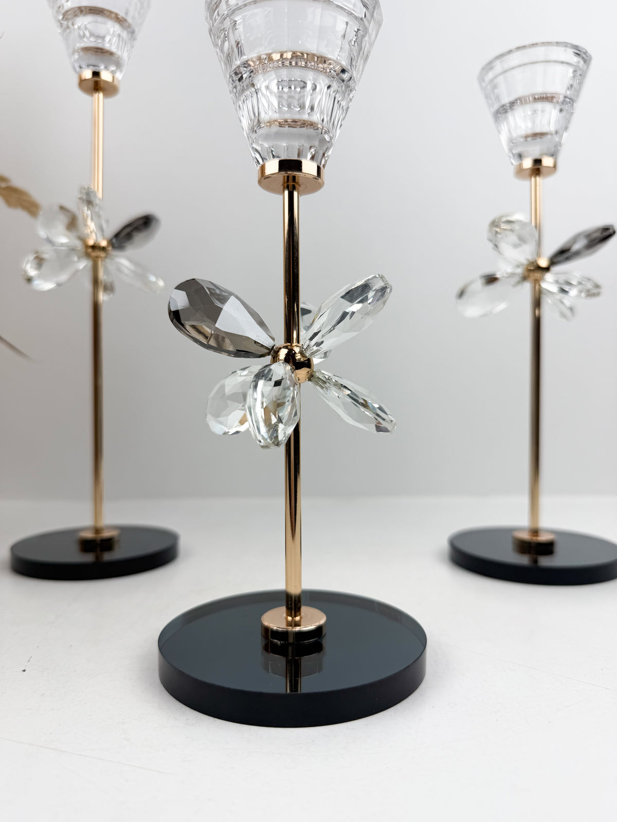 Trio de Bougeoirs décoratif contemporain fleur en cristal sur un socle noir.