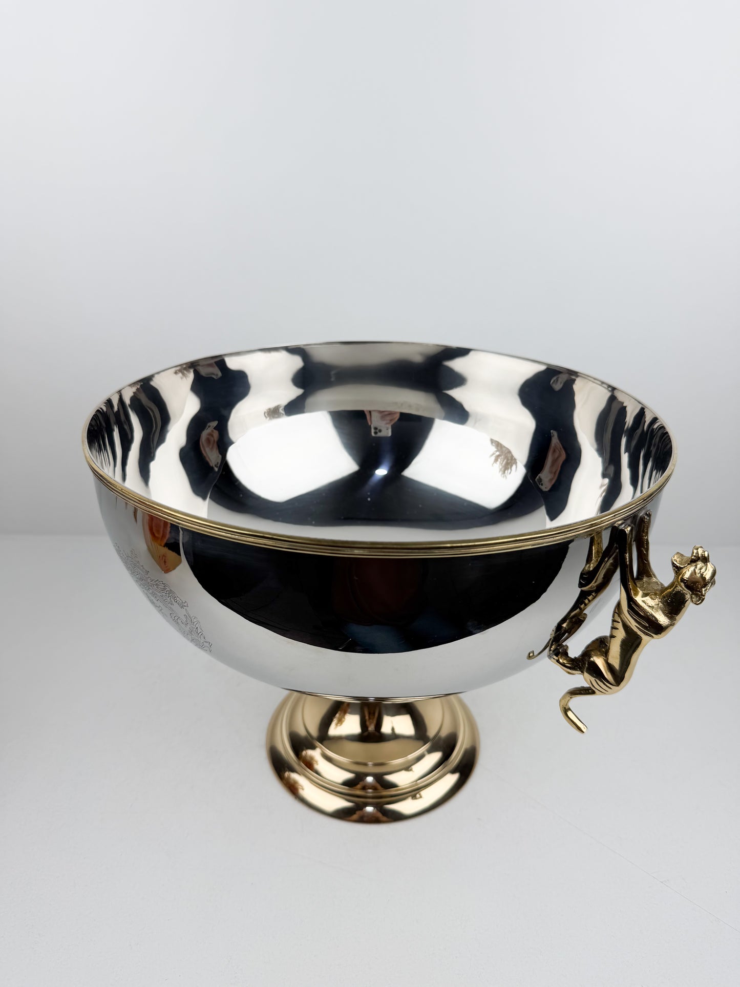Présentoir très chic et luxe en métal miroir avec pieds dorés et poignées en forme de tigre.