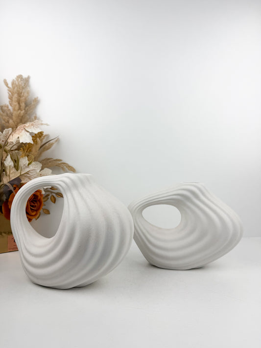 Duo de vases en céramique blanc mat aux formes géométriques épurées.