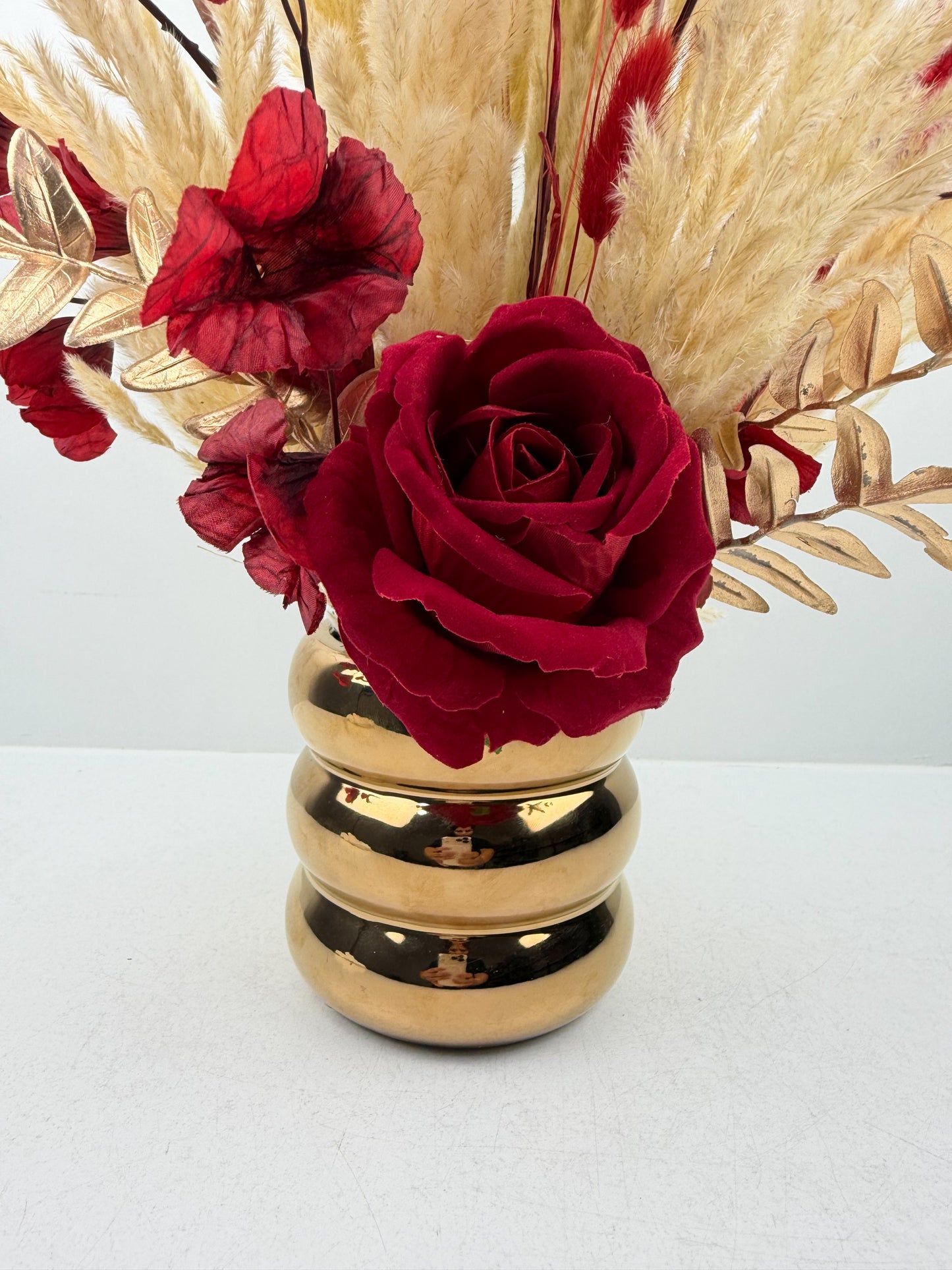 Fleurs séchées très chic aux teintes beiges naturelles par une délicate fleur rouge qui apporte une touche de couleur et d'élégance.