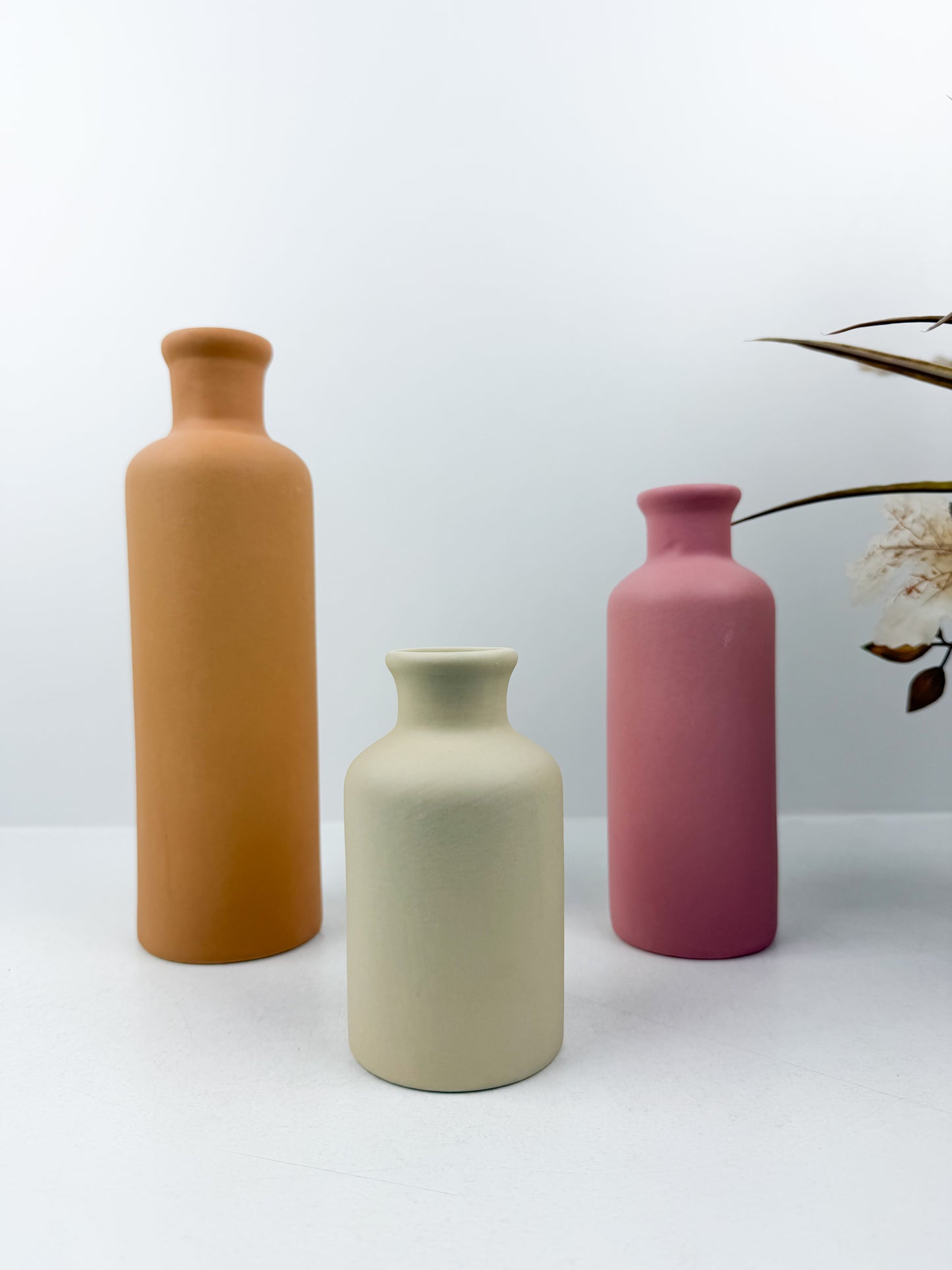 Ensemble de trois vases en céramiques aux couleurs éclatantes épurées et élégantes.