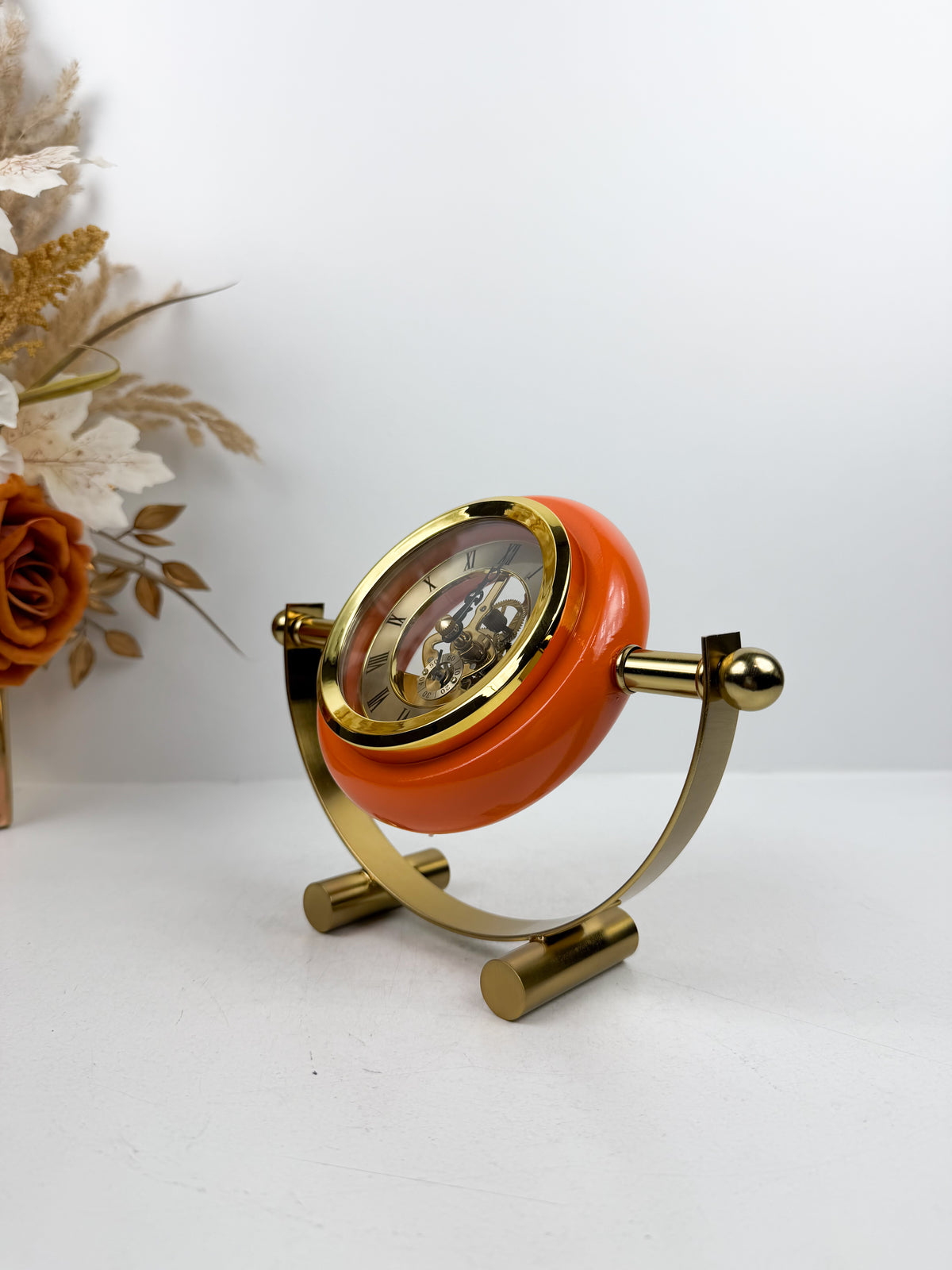 Horloge de table en métal doré de contour orange.