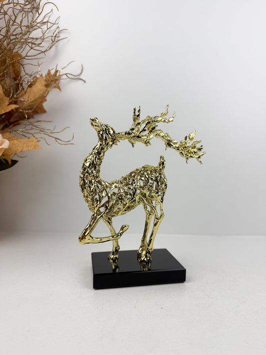 Sculpture de gazelle dansante en métal doré sur un socle noir en cristal , incarnant l'élégance et la grâce.
