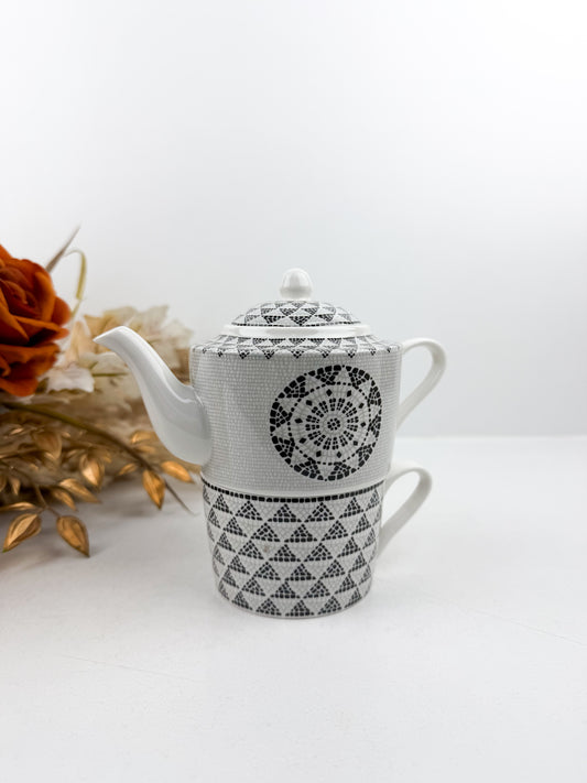 Théière élégante accompagnée d'une tasse à café au lait aux motifs treillis noir et blanc