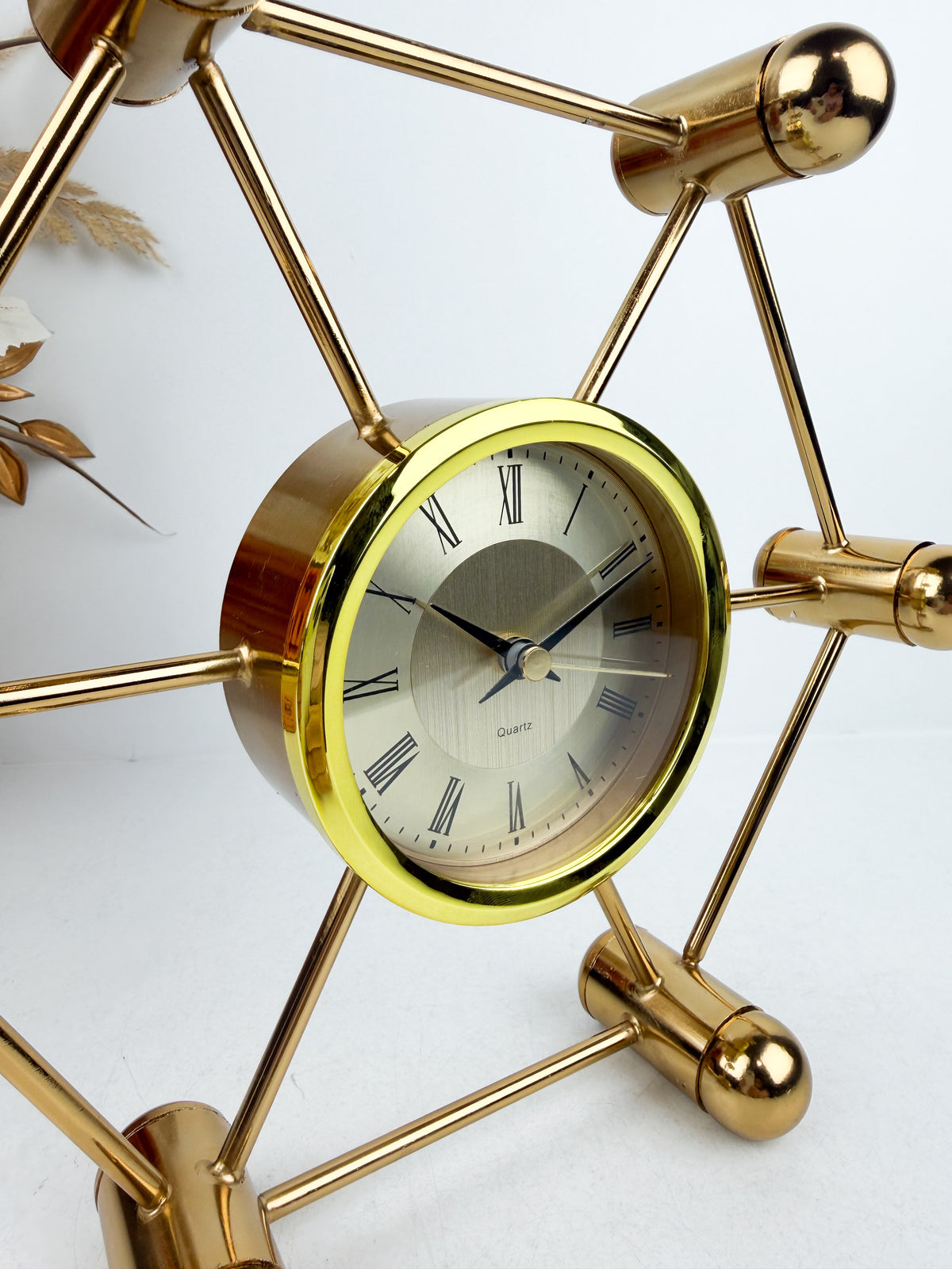Horloge décoratif en métal doré aux lignes géométriques épurées.