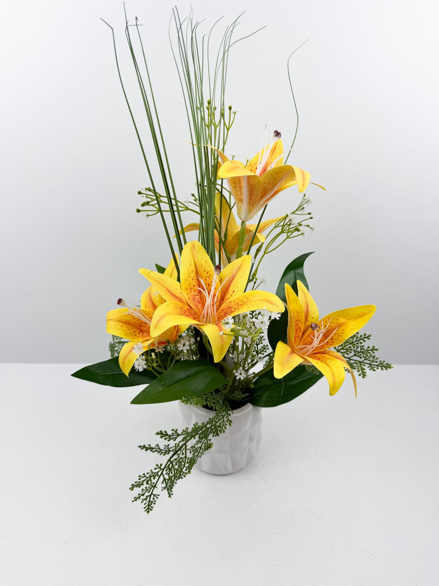Fleurs artificielles jaunes délicates dans un élégant pot blanc en céramique de luxe.