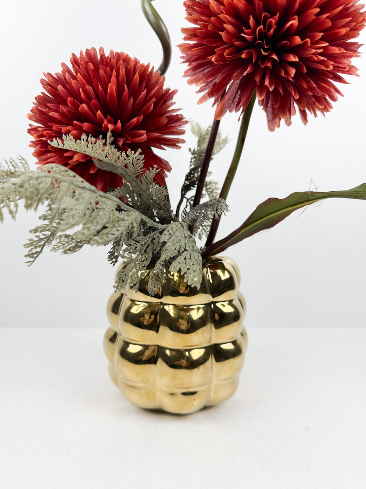 Fleurs artificielles élégantes en forme de pompons rouges élégantes.