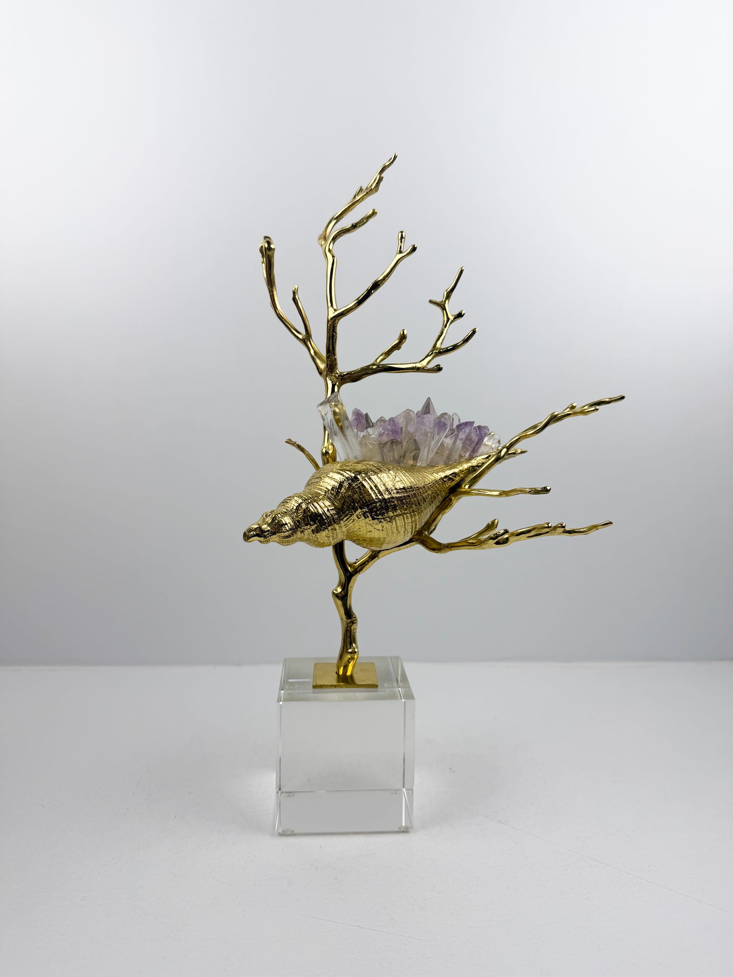 Sculpture de luxe de forme coquillage alliant l'élégance intemporelle du laiton doré aux reflets captivants des cristaux naturels.