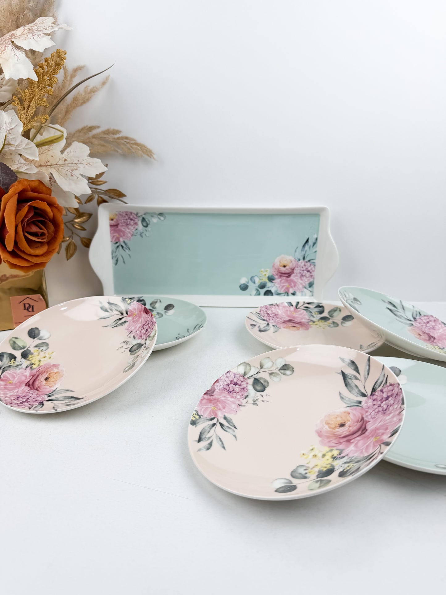 Grande assiette de service accompagnée de six assiettes assorties aux motifs floraux
