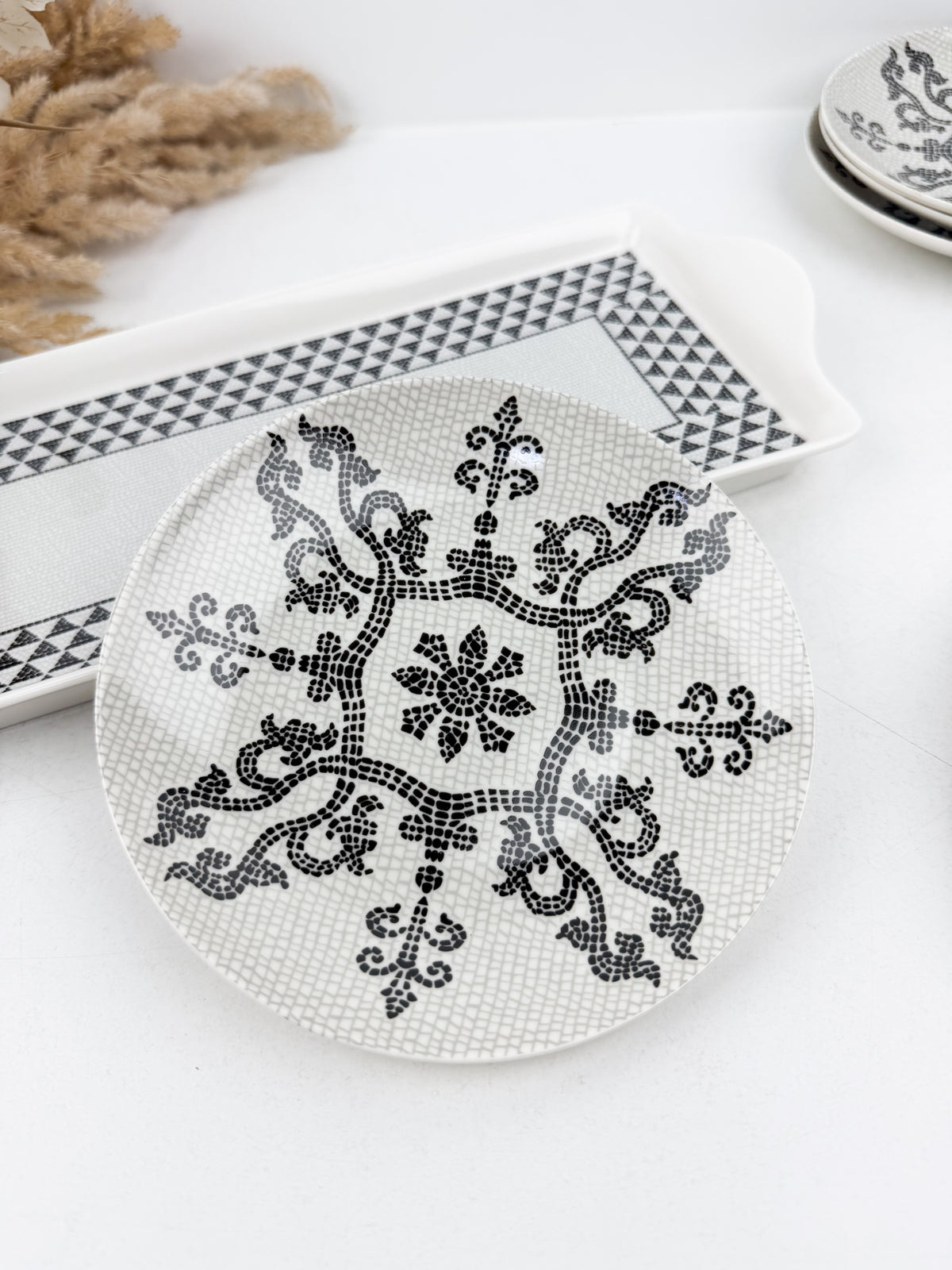 Ensemble de service élégant d'une grande assiette de présentation et de six assiettes assorties ornées en noir et blanc