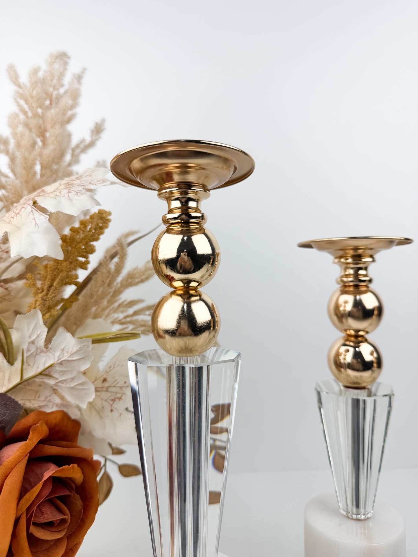Ensemble élégant de bougeoirs en cristal et métal doré sur un socle en marbre blanc.