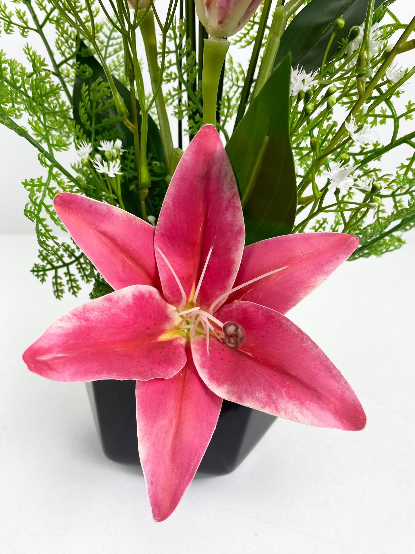 Vase noir avec fleurs artificielles rose