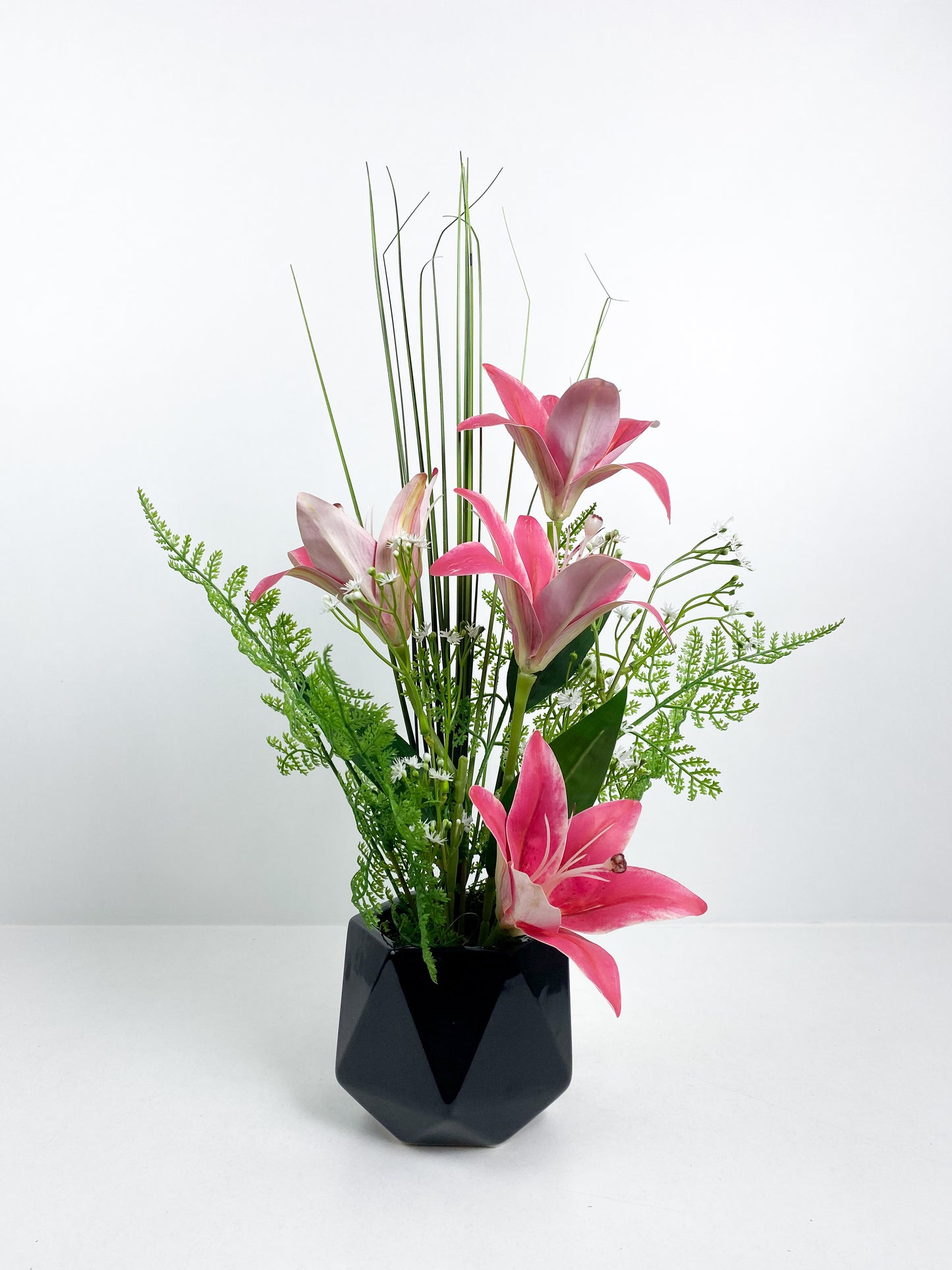 Vase noir avec fleurs artificielles rose