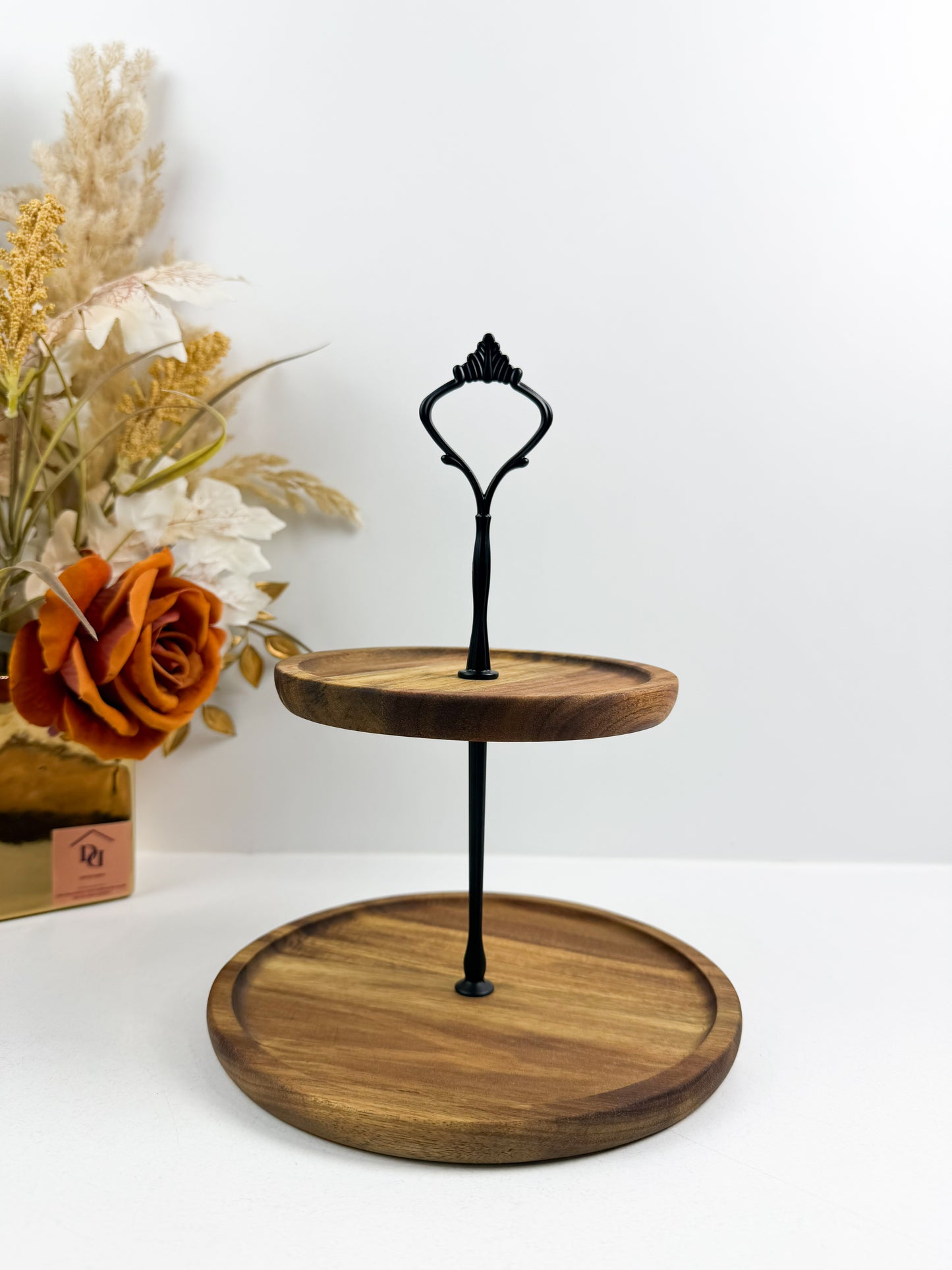 Présentoir à gâteaux à 2 étages en bois avec une poignée noire.