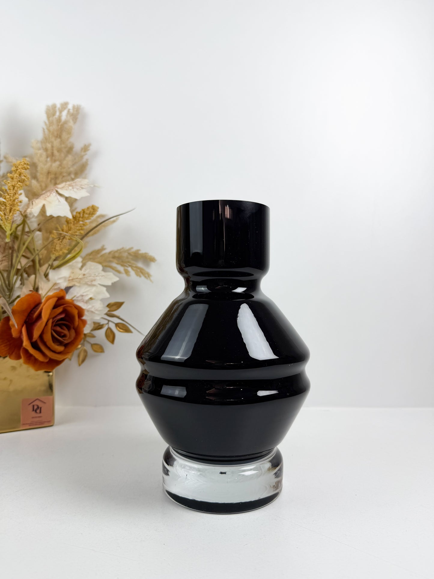 Vase design en verre noir brillant avec une base transparente