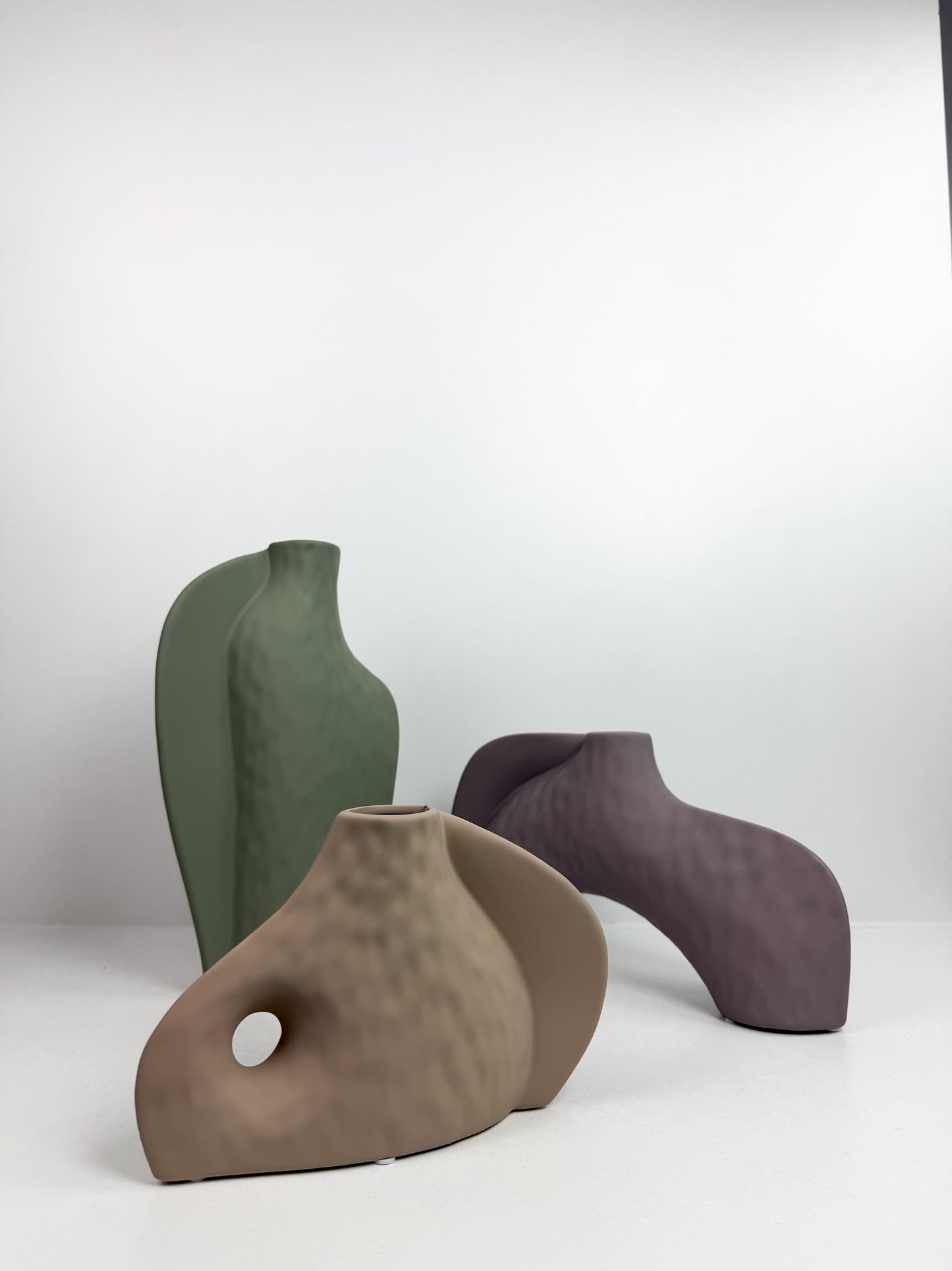 Trois vases décoratifs en céramique aux formes abstraites et aux couleurs neutres