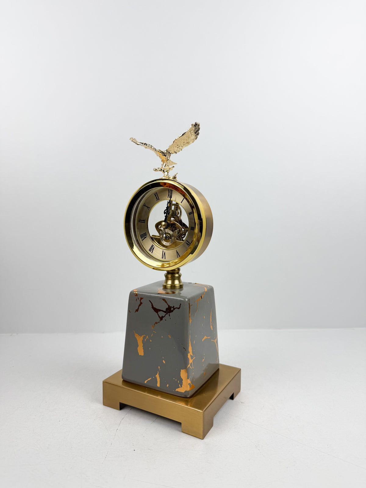Horloge ronde avec cadran classique surmontée d'une sculpture d'aigle