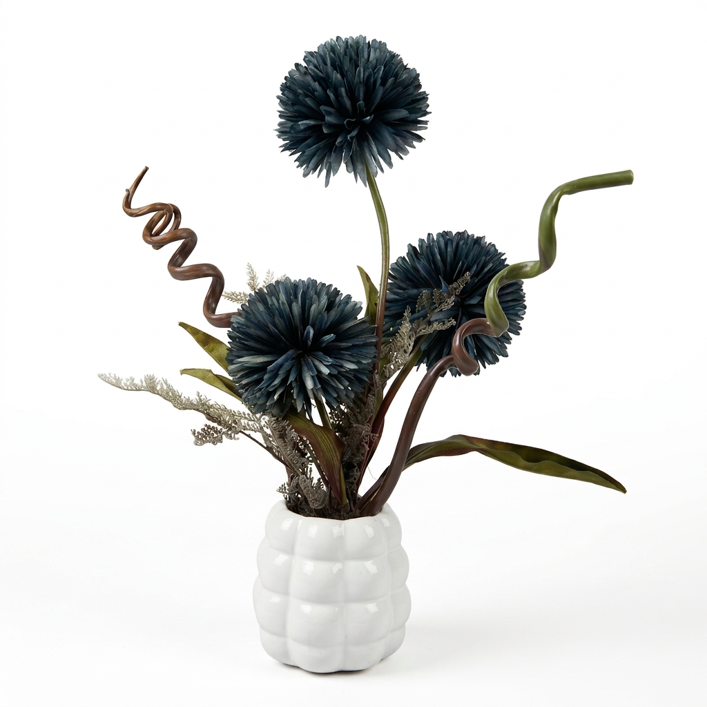 Fleurs artificielles élégantes en forme de pompons éclatantes dans un vase blanc de forme ronde.