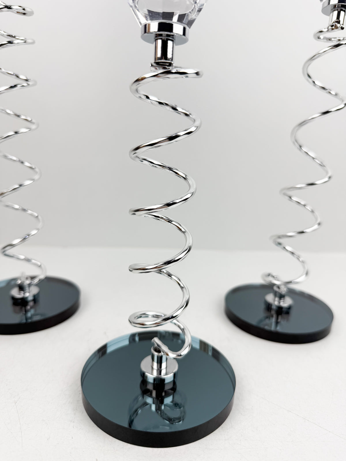 Trio de Bougeoirs en cristal argentée sur un socle noir.