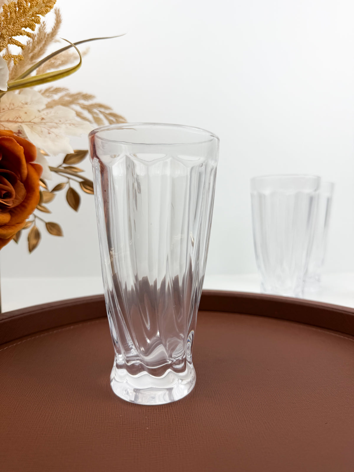 Service en verre transparent composé d'une carafe et de six verres assortis à motifs géométriques.
