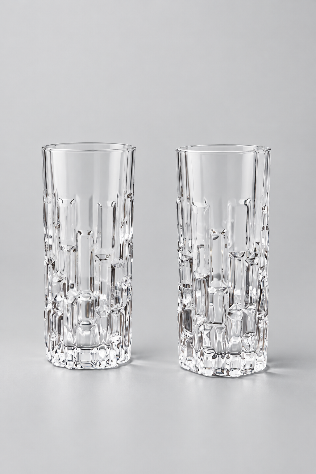 Six verres transparents ciselés en verre texturé à motifs géométriques en relief.