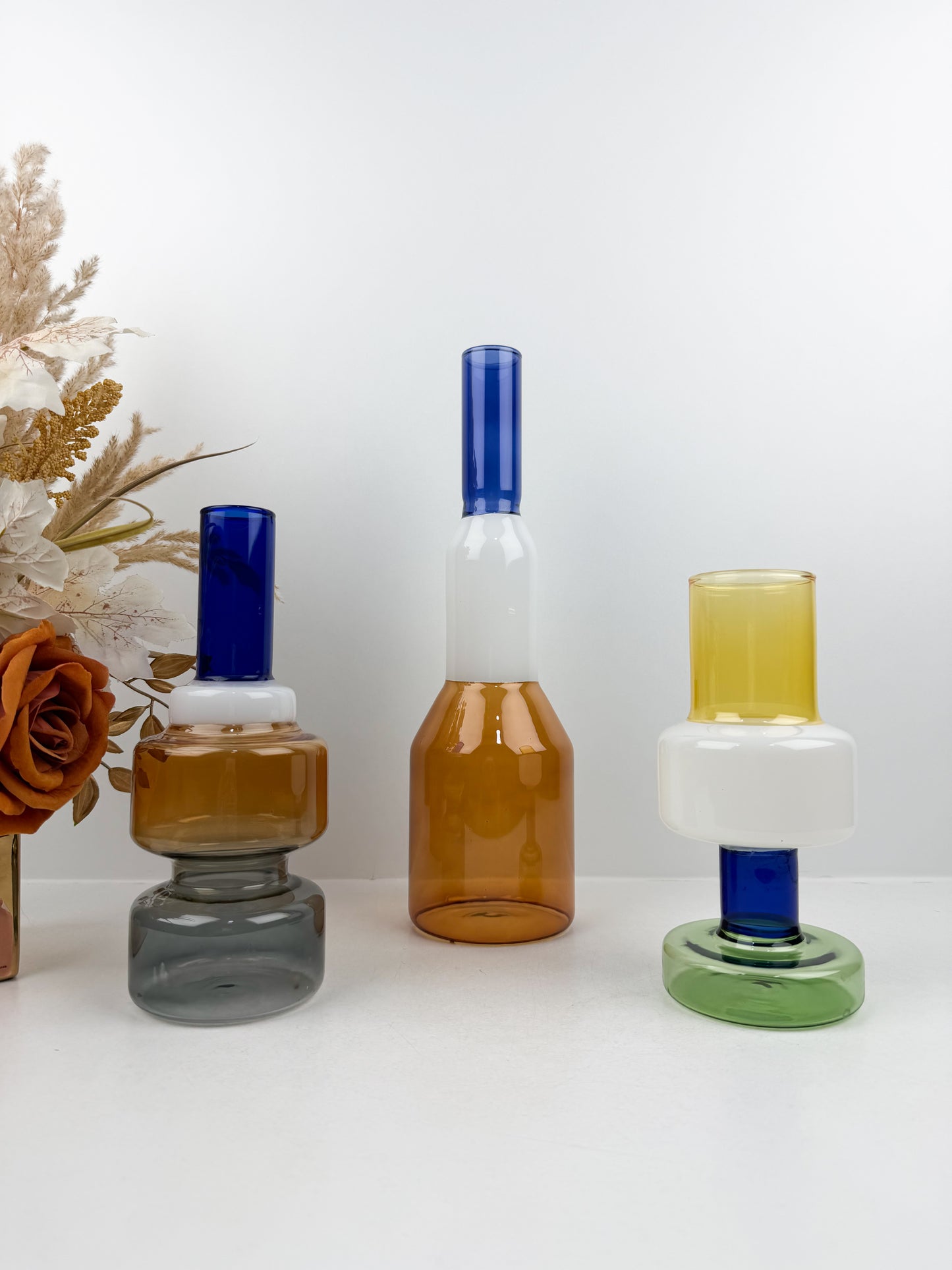 Trio de vases géométriques aux formes épurées et aux couleurs variées.