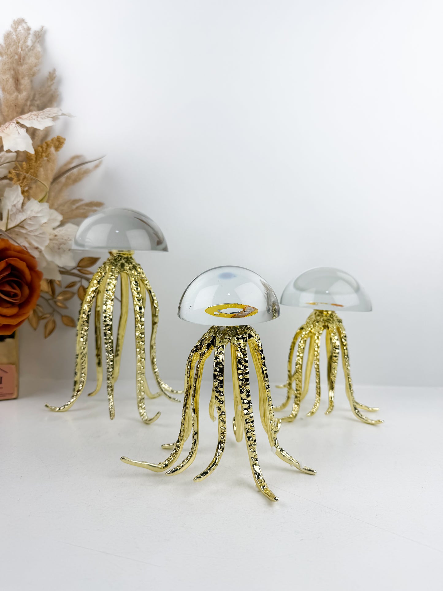 Trois sculptures de méduses dorées en métal avec un dôme en cristal