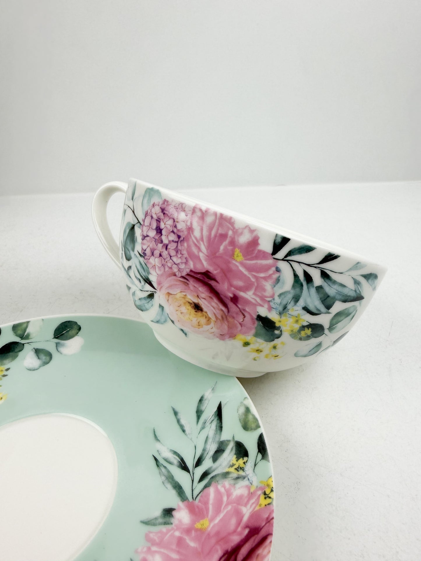 Théière élégante d'une tasse accompagnée de sous-tasse raffinée de motif floral