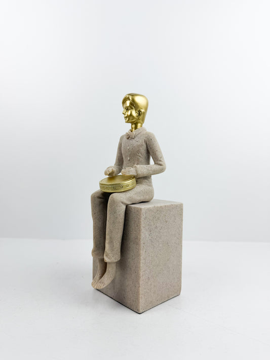 Figurine décorative représentant un musicien assis jouant du tambour