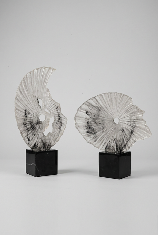 Sculpture décorative plissée en résine sur un socle en cristal noir élégant.