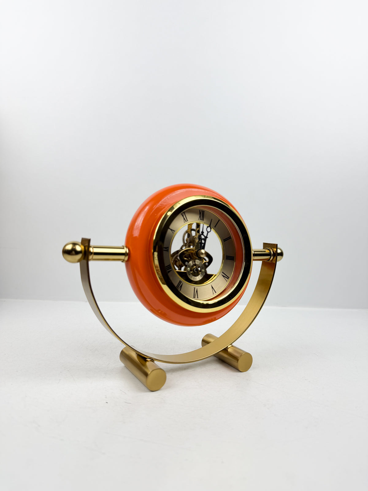 Horloge de table en métal doré de contour orange.