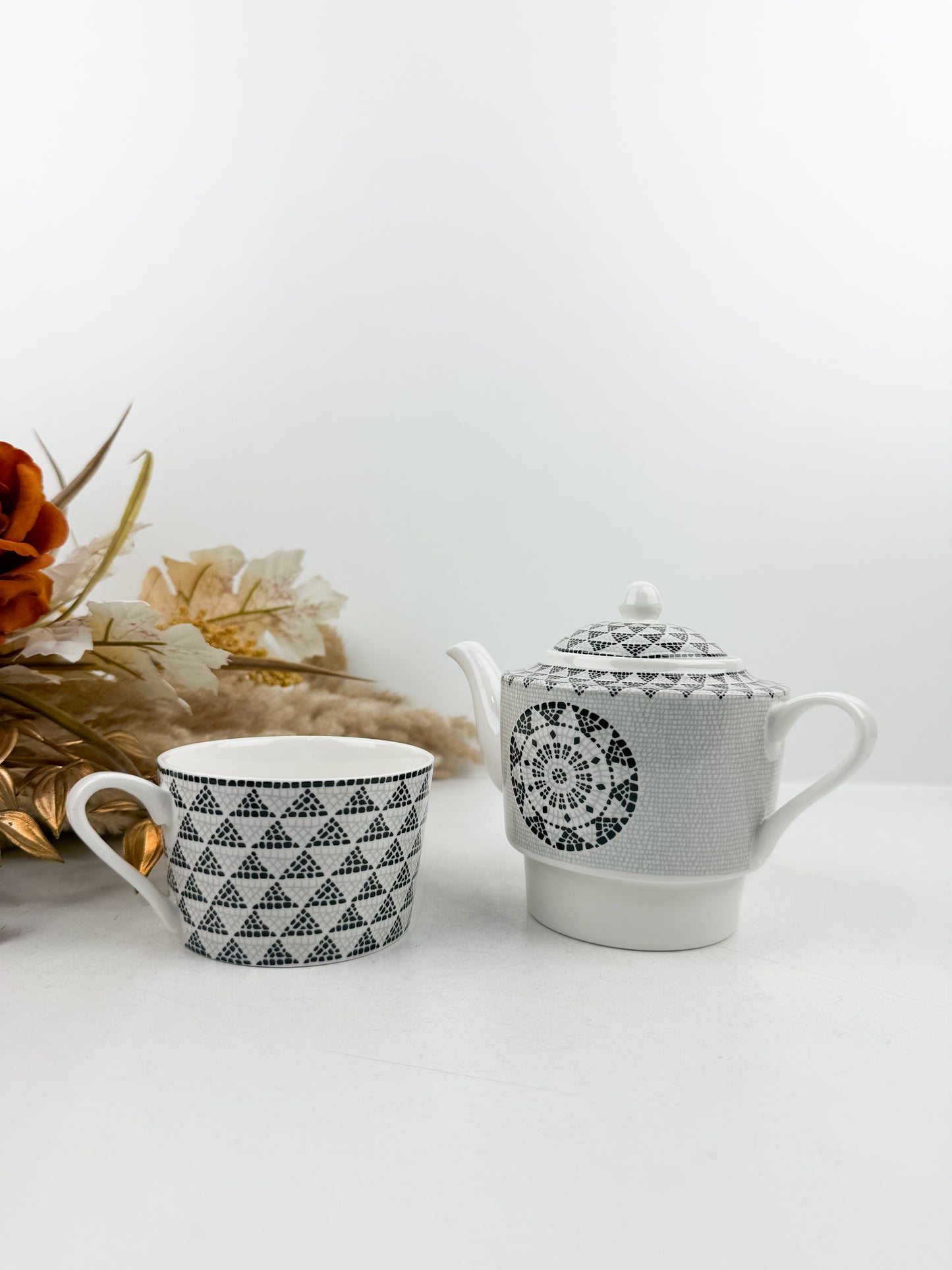 Théière élégante accompagnée d'une tasse à café au lait aux motifs treillis noir et blanc