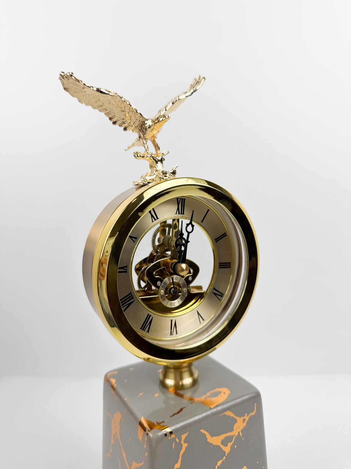 Horloge ronde avec cadran classique surmontée d'une sculpture d'aigle