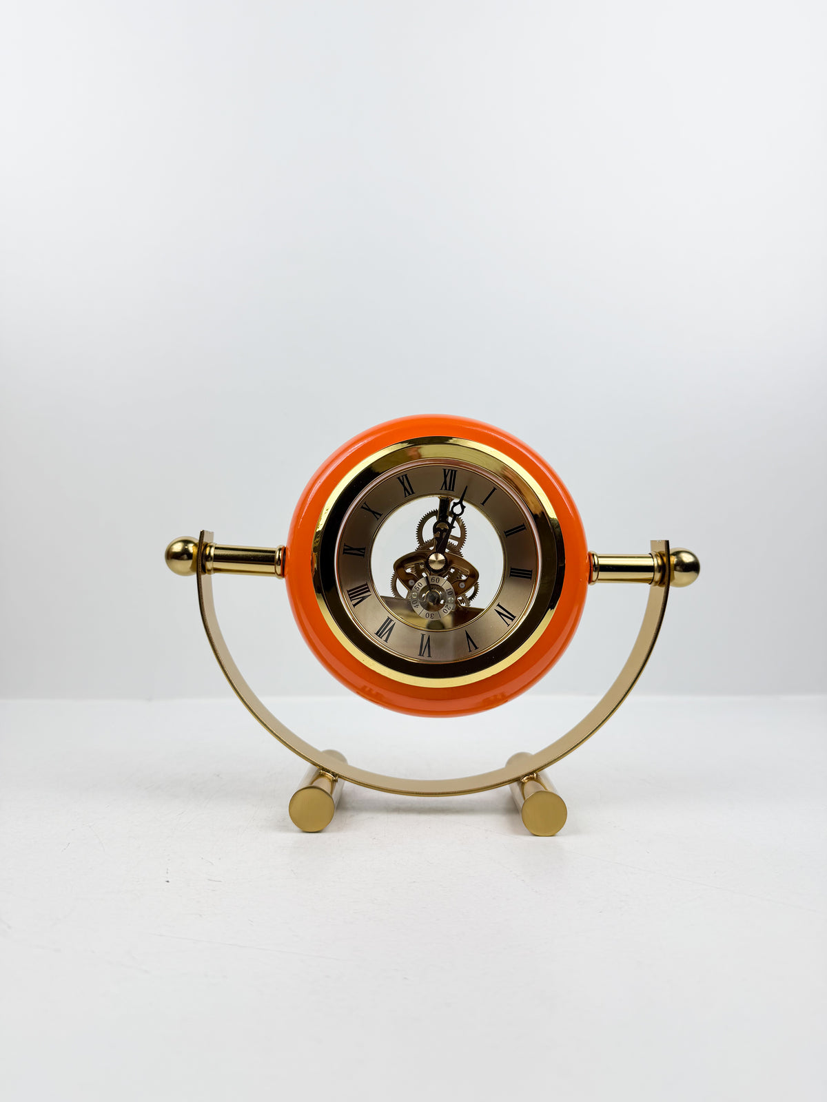 Horloge de table en métal doré de contour orange.