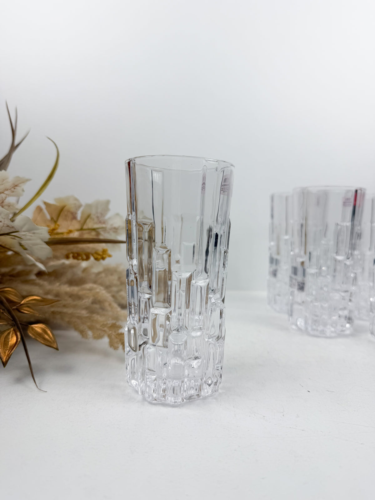 Six verres transparents ciselés en verre texturé à motifs géométriques en relief.